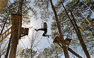 Kid swinging through ropes course